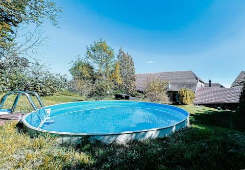 eine große Wanne, die auf dem Rasen im Hof sitzt in der Unterkunft Maison le Bonheur - 12P Met Zwembad FR Vakantiehuis in Magny-lès-Jussey