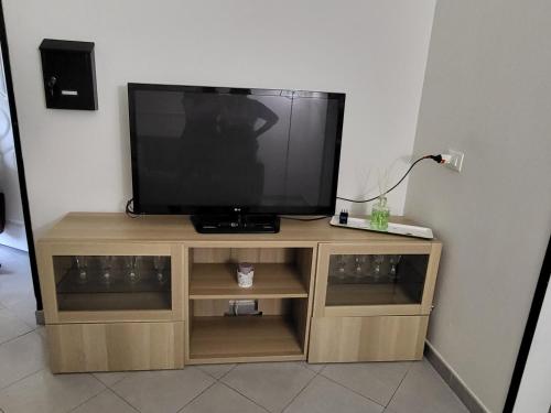 a television on a wooden stand in a room at L'appoggio perfetto in Viareggio