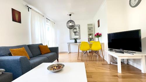 a living room with a blue couch and yellow chairs at Amazing Location - City of London- 2 Bedroom Stunning Canal View House With Private Garden,Parking & Balcony in London