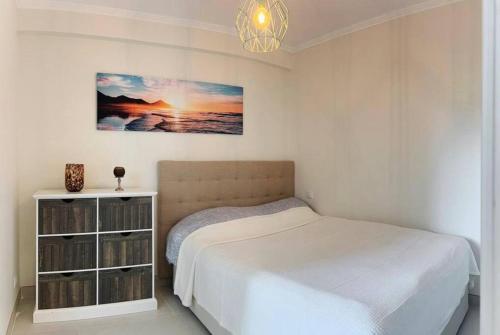 Habitación blanca con cama y lámpara de araña. en Cunit, front line with sea view, en Cunit