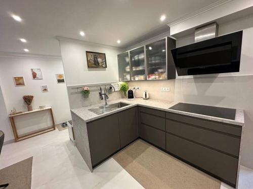 a kitchen with a sink and a tv on the wall at Cunit, front line with sea view in Cunit