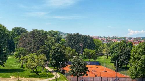 um campo de ténis num parque com árvores em Park & Play em Banja Luka