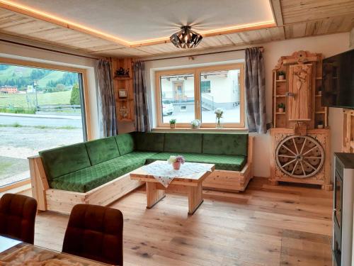 a living room with a green couch and a table at Tristner Appart in Schwendau
