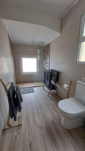 a small bathroom with a toilet and a window at Villa de Bruma Faial da Terra in Faial da Terra
