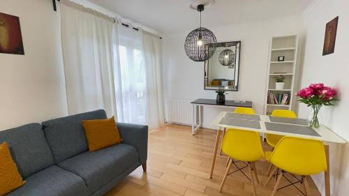 a living room with a couch and a table with yellow chairs at Amazing Location - City of London- 2 Bedroom Stunning Canal View House With Private Garden,Parking & Balcony in London