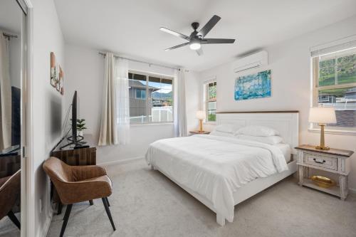 una camera bianca con letto e ventilatore a soffitto di New Mountainside Home Near Spectacular Beaches a Waianae