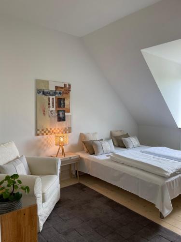 - une chambre blanche avec un lit et un canapé dans l'établissement Dobbelt værelse Carlsminde, à Stenstrup
