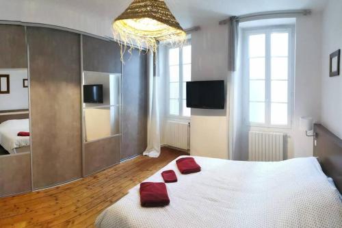 une chambre avec un lit avec deux oreillers rouges dessus dans l'établissement Agréable maison de ville, de 1 à 6 personnes, à 5 min à pied du centre ville de Cognac, à Cognac