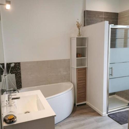 une salle de bain avec une baignoire blanche et un lavabo dans l'établissement Agréable maison de ville, de 1 à 6 personnes, à 5 min à pied du centre ville de Cognac, à Cognac