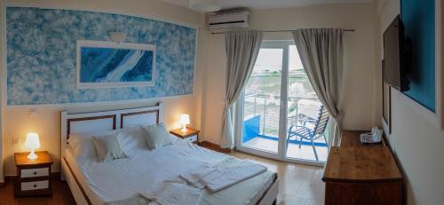 een slaapkamer met een groot bed en een balkon bij Atena Hotel in Costinesti