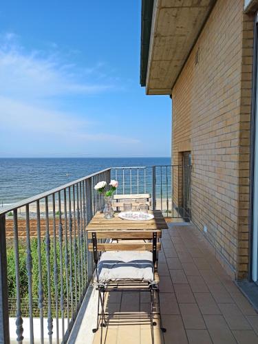 un tavolo e sedie su un balcone con vista sull'oceano di Casa Vacanze Appartamento Bijoux a Civitanova Marche