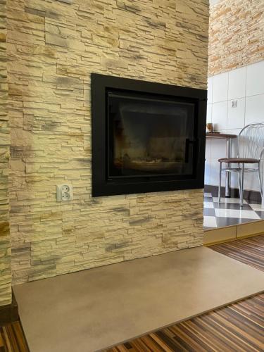 a living room with a stone wall with a fireplace at Agroturystyka ‚U Misia’ in Krzywopłoty