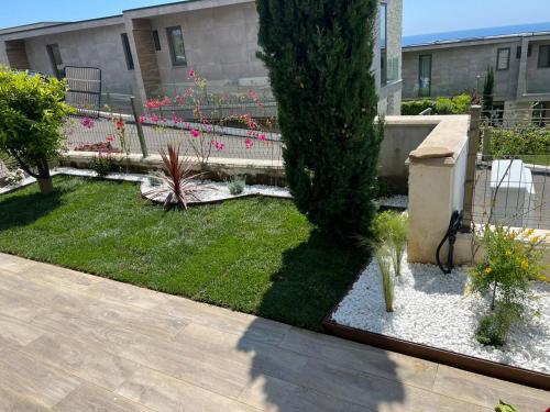 a garden with a fence and a tree in a yard at Private Villa at Olea Luxury Resort in Dhërmi