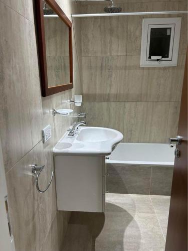 a bathroom with a sink and a bath tub at Departamentos Agringof 2 in Balcarce