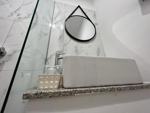 een spiegel en een laptop op een aanrecht in de badkamer bij Atena Hotel in Costinesti