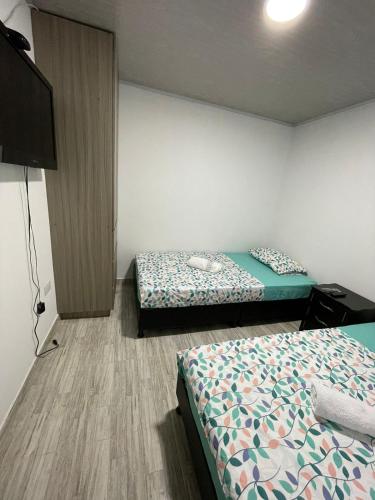 um quarto com 2 camas e uma televisão de ecrã plano em Apacel em Cartago