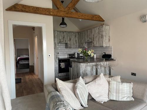 ein Wohnzimmer mit einem Sofa und einer Küche in der Unterkunft Holly Cottage in Gringley on the Hill