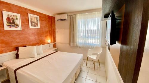 ein Hotelzimmer mit einem Bett und einem Fenster in der Unterkunft Beira Mar 226 Praia - NBI - Ponta Negra Beach - Pe na areia e ultimo andar e Vista x Mar in Natal