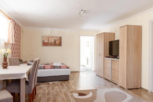 1 dormitorio con cama, mesa y TV en Piknik Vendégház, en Bogács