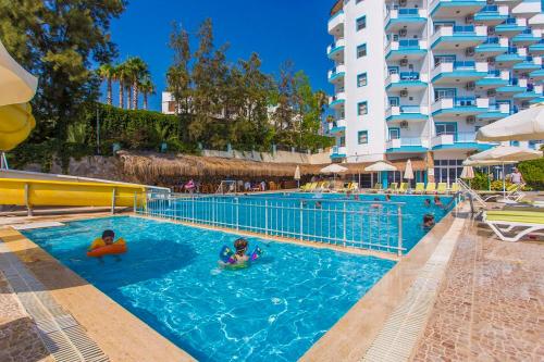 Club Sun Paradise Hotel في ألانيا: مسبح في فندق فيه ناس في الماء