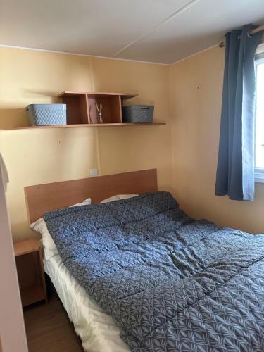 une chambre avec un lit avec une couette bleue dans l'établissement Mobil home les sables d or, au Grau-dʼAgde