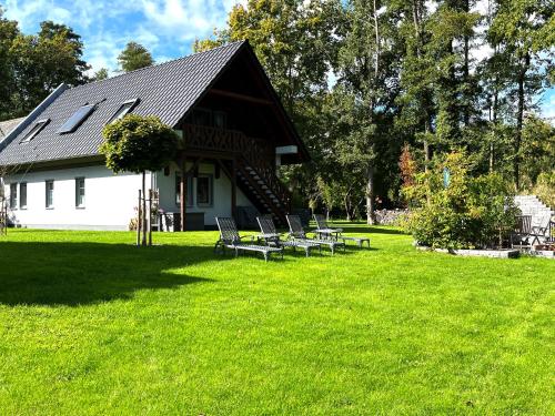 a group of chairs sitting in the grass in front of a house at Ferienwohnungen Ast in Burg