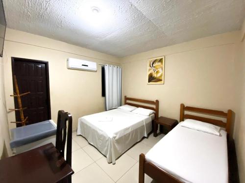 pokój hotelowy z 2 łóżkami i oknem w obiekcie Hotel Rio w mieście Tucuruí