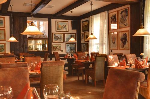 un comedor con mesas, sillas y luces en Hotel Schwalenberger Malkasten, en Schieder-Schwalenberg