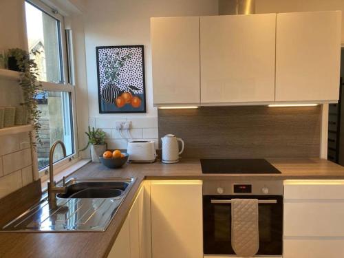 a kitchen with a sink and a stove top oven at Garden Apartment, Central Harrogate with parking in Harrogate