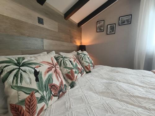 um quarto com uma cama com almofadas tropicais em Cassandre em Erde
