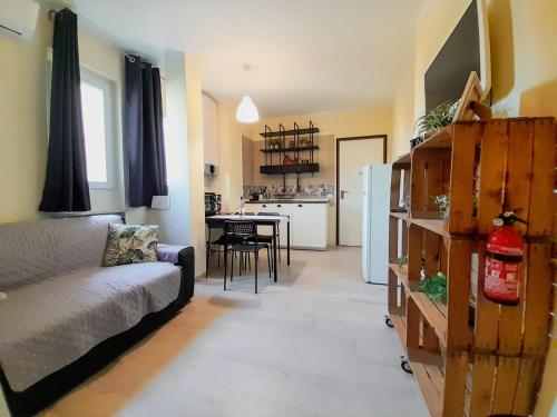 a living room with a couch and a kitchen with a table at MAJA HOME in Lazise