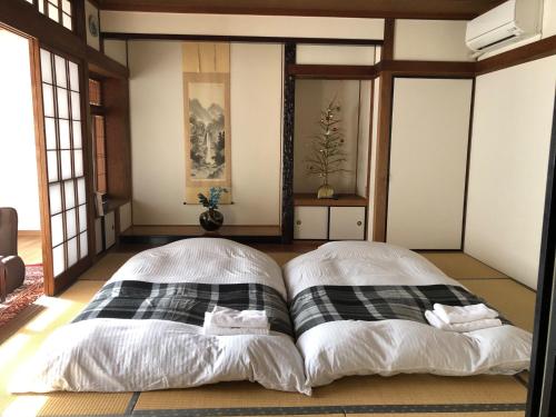 1 dormitorio con 2 camas en una habitación con ventanas en Ogi - House - Vacation STAY 33925v en Saga