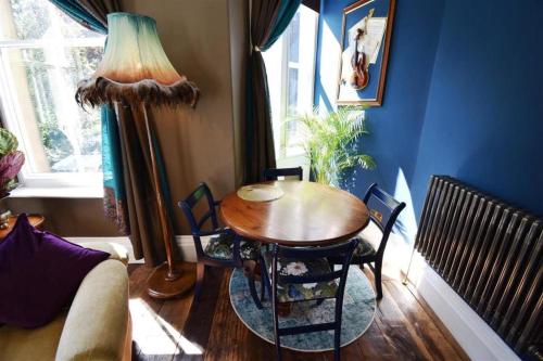 a dining room with a table and chairs and a window at The Huntress Suite in Buxton
