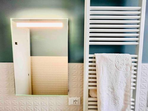La salle de bains est pourvue d'un miroir et de serviettes sur une étagère. dans l'établissement Casa Bonita Bolognina, à Bologne
