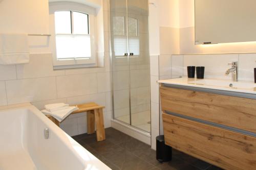 a bathroom with a tub and a sink and a shower at Ferienwohnung Fritz in Jork