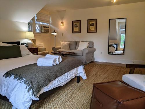 a bedroom with a bed and a couch and a mirror at Stanton House Inn in Greenwich