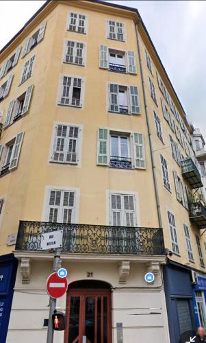 - un bâtiment jaune avec des fenêtres et un balcon dans l'établissement RMB - T2 au Dernier étage au coeur de Nice, à Nice