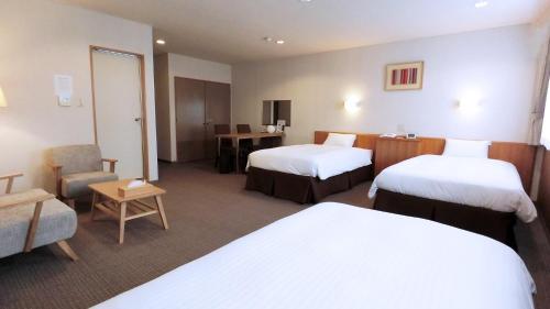 ein Hotelzimmer mit 2 Betten und einem Stuhl in der Unterkunft Yurihonjo - Hotel - Vacation STAY 42526v in Yurihonjo