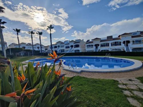 ein Resortpool mit Palmen im Hintergrund in der Unterkunft Altomar2, Gran Alacant, Alicante in Gran Alacant