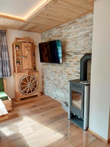 a living room with a stove and a tv on a brick wall at Tristner Appart in Schwendau