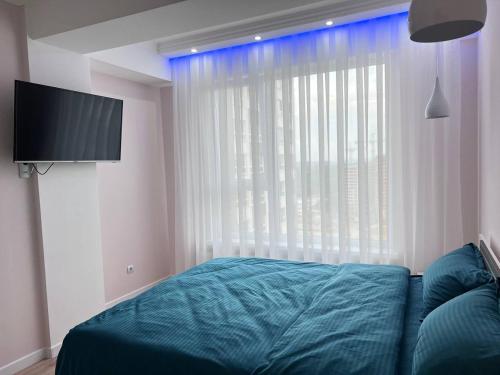 a bedroom with a bed and a large window at Soft Aparts in Chişinău
