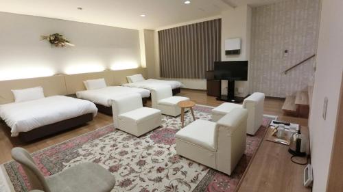 Habitación de hotel con 2 camas y sala de estar. en Yurihonjo - Hotel - Vacation STAY 42543v en Yurihonjo