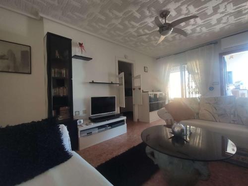 ein Wohnzimmer mit einem Sofa und einem TV in der Unterkunft Altomar2, Gran Alacant, Alicante in Gran Alacant