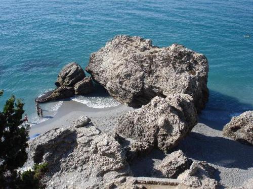 a group of rocks on a beach near the ocean at Hotel Rural Almazara in Frigiliana