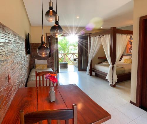 a dining room with a table and a bedroom at Pousada Oasis Paracuru in Paracuru