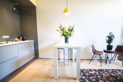 a white table with flowers on it in a room at Amsterdam House of Arts & Crafts in Amsterdam