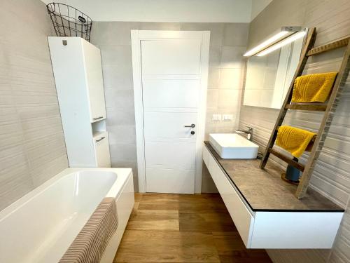 a bathroom with a tub and a sink and a mirror at Villa Gina Poreč in Nova Vas