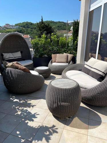 a patio with wicker chairs and tables on a balcony at Holiday Home Barska Vila in Bar
