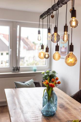 a vase of flowers on a table with lights at City-House-Achern in Achern