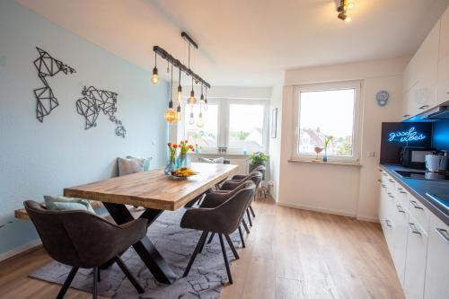 a kitchen and dining room with a wooden table and chairs at City-House-Achern in Achern